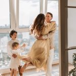 A joyful family embraces in a sunlit modern apartment, celebrating togetherness and love.