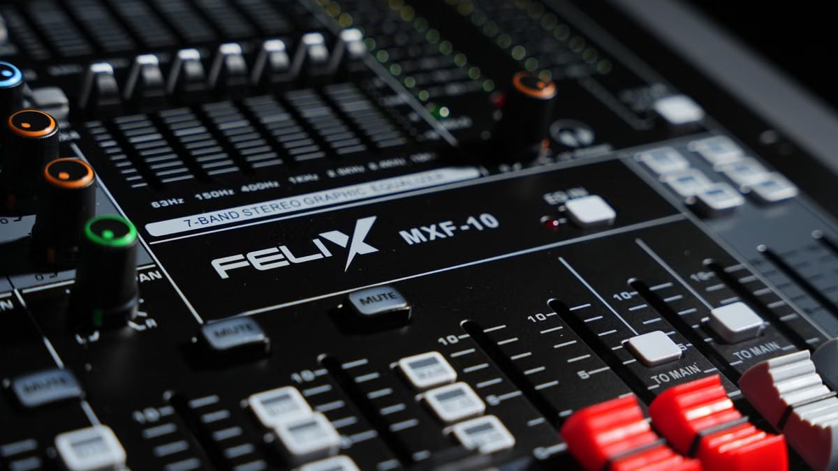 Detailed view of a professional audio mixer in a recording studio, featuring various knobs and sliders.